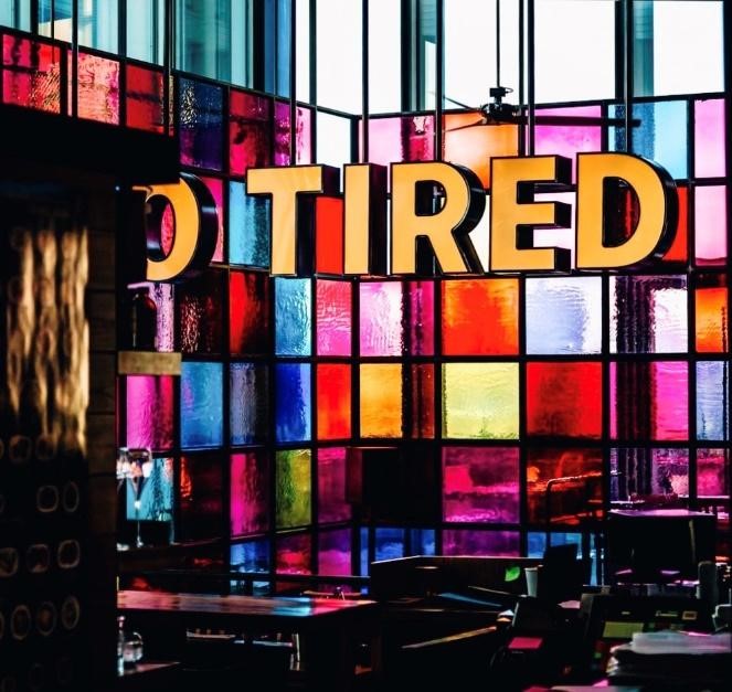 Office space with colorful glass windows with the words Tired.