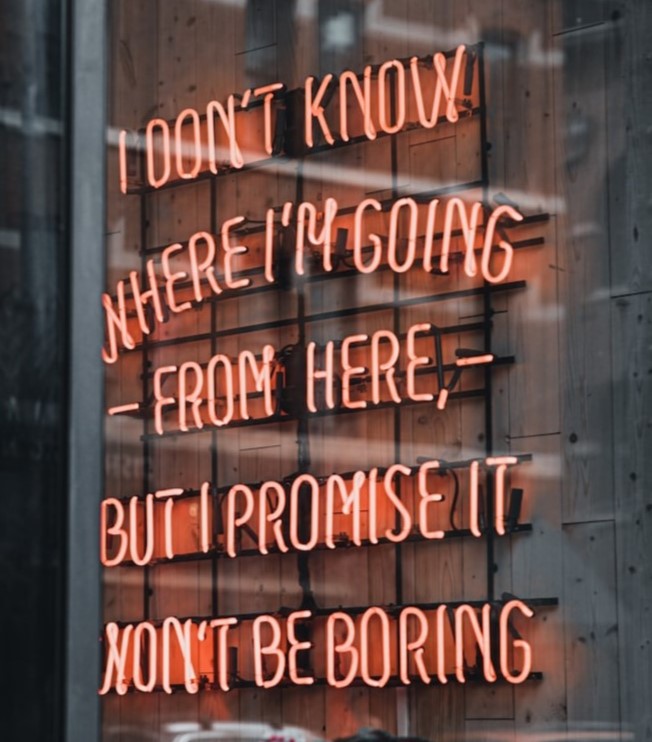 Neon sigh in a window that says " I don't know where I'm going from here, but I promise It won't be boring"