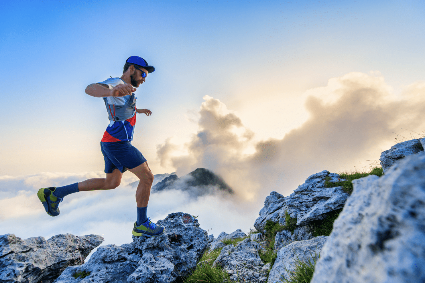 A hiker on top of a mountain walking on the rocks