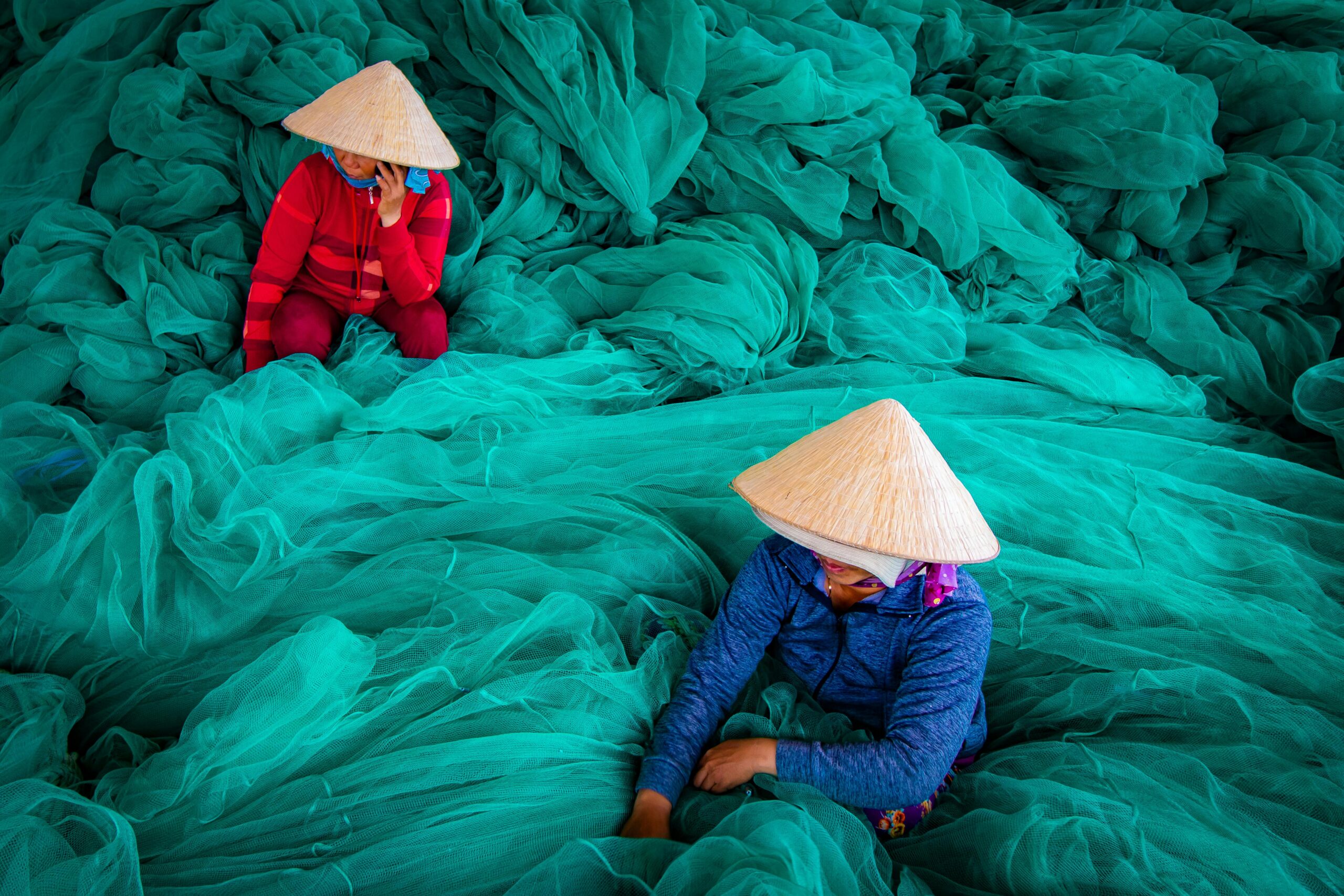 Women in Cambodia around blue fabric. 